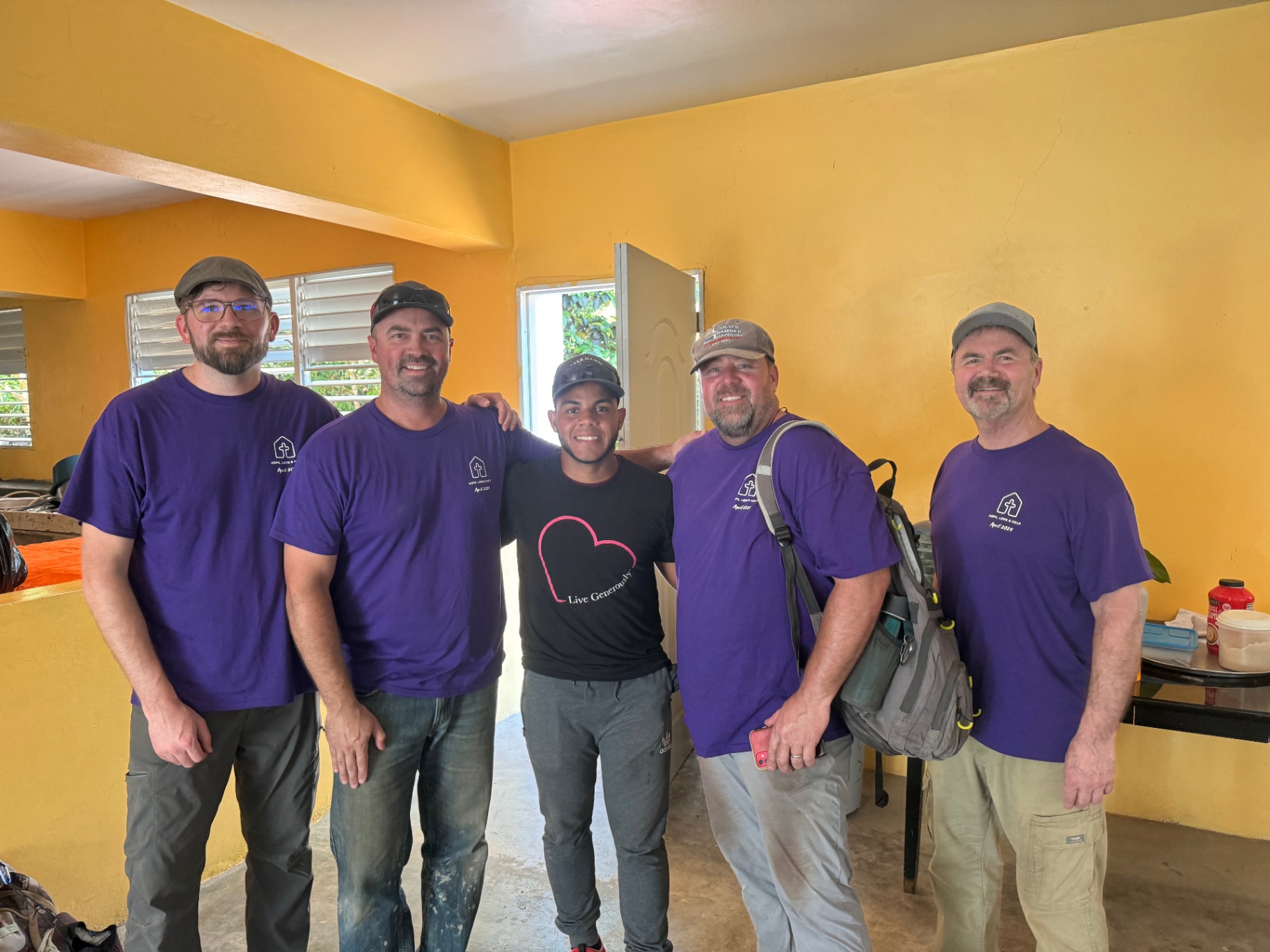Group of volunteers in matching shirts with a local friend