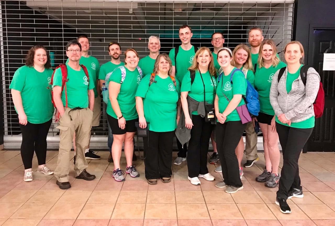 Volunteer team in green shirts gathered at the airport