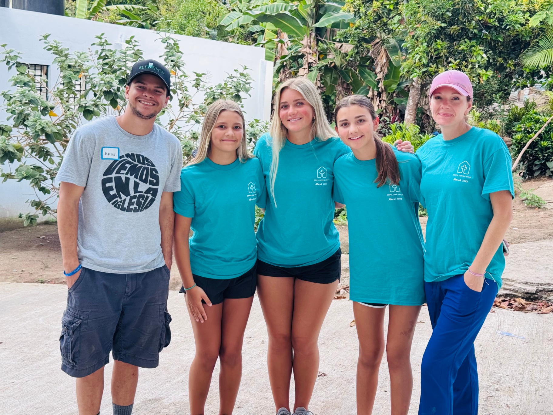 Volunteer team standing together outdoors in matching trip shirts