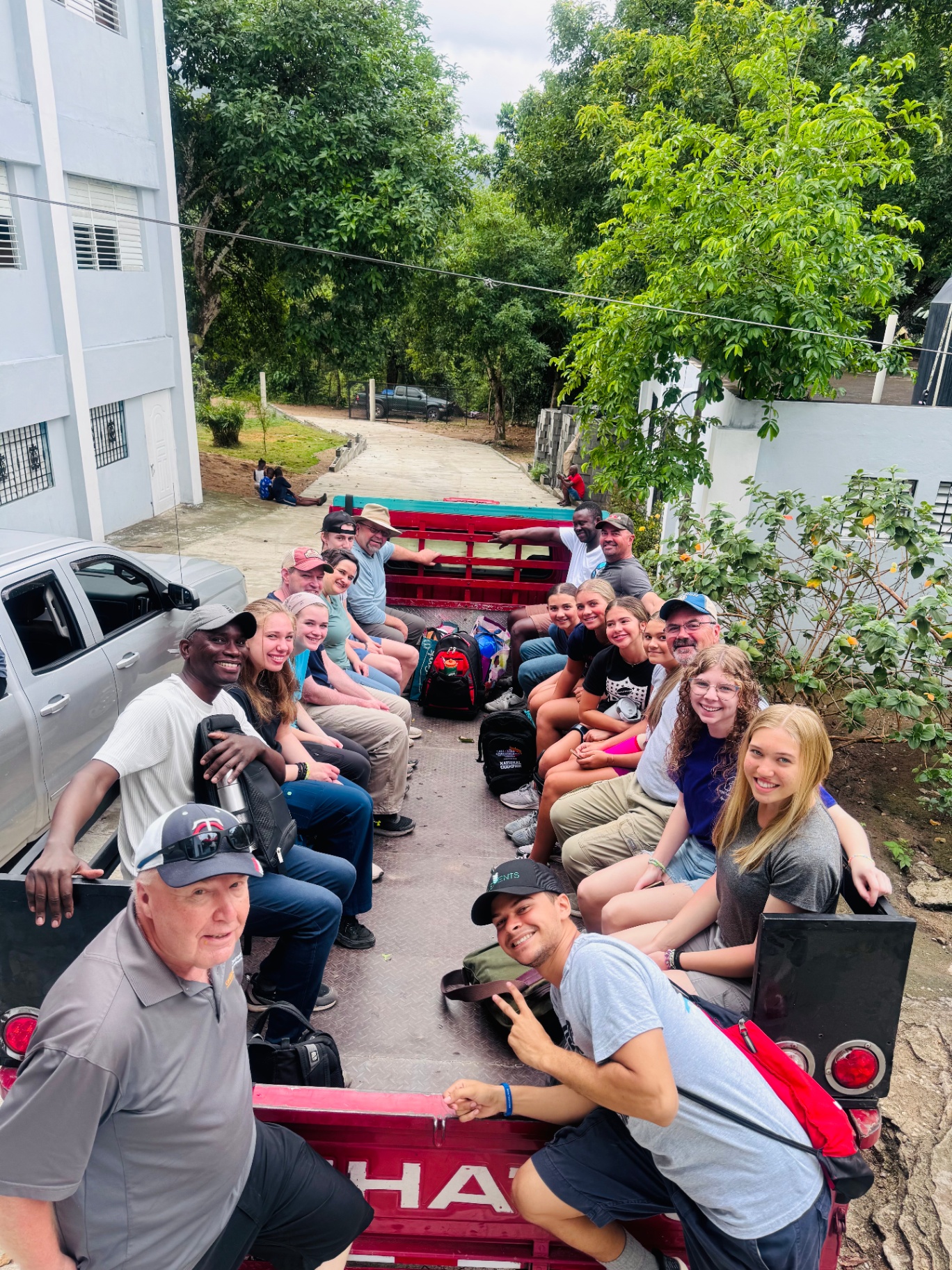 Large volunteer team riding together in a truck bed
