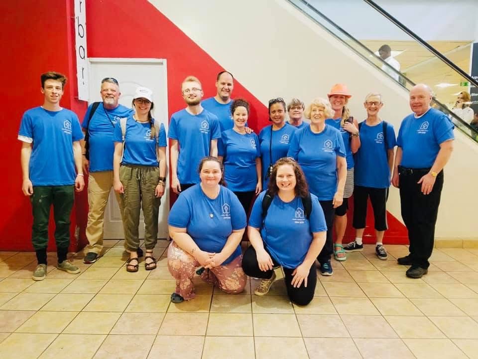 Volunteer team in blue shirts gathered at the airport