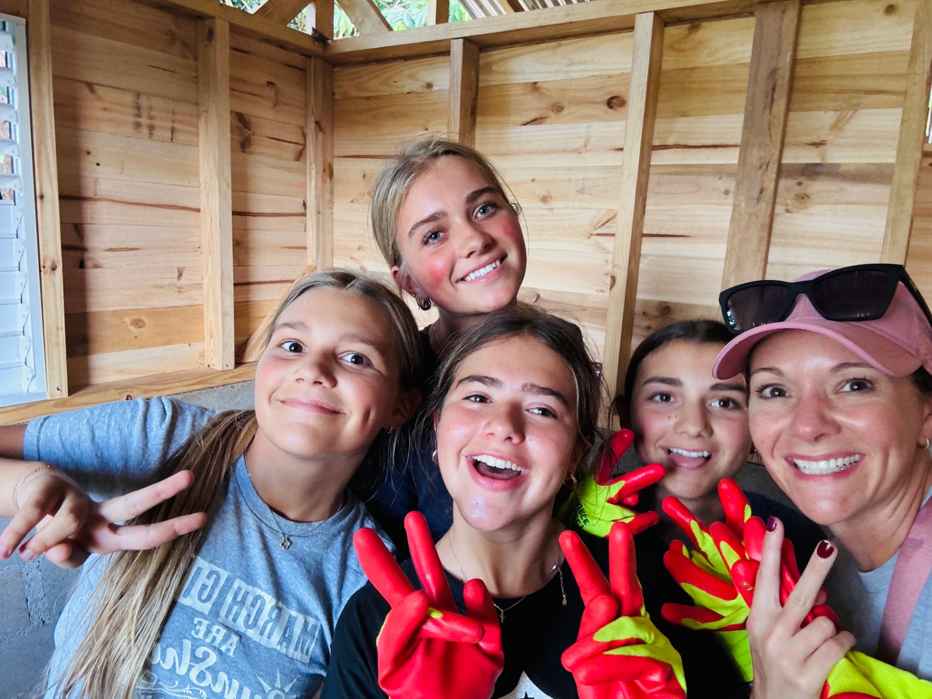 Group selfie of volunteers smiling inside a newly built home