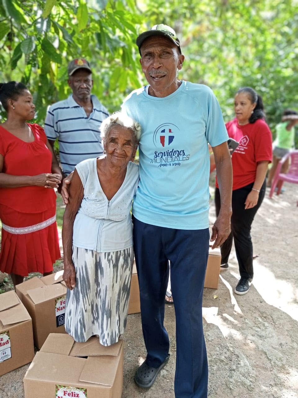 Volunteer embracing an elderly local woman during a food delivery