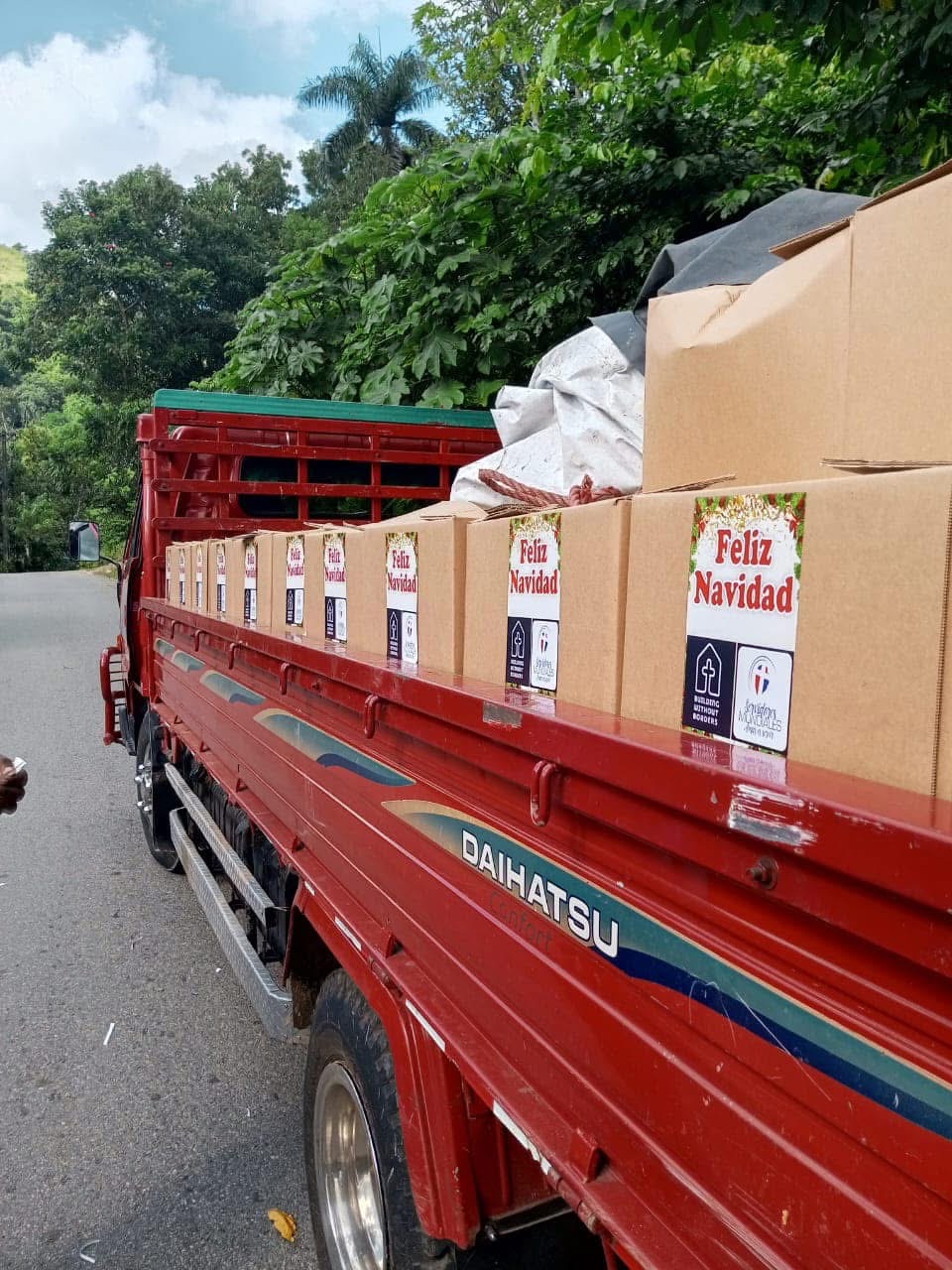 Red truck loaded with 'Feliz Navidad' food boxes ready for delivery