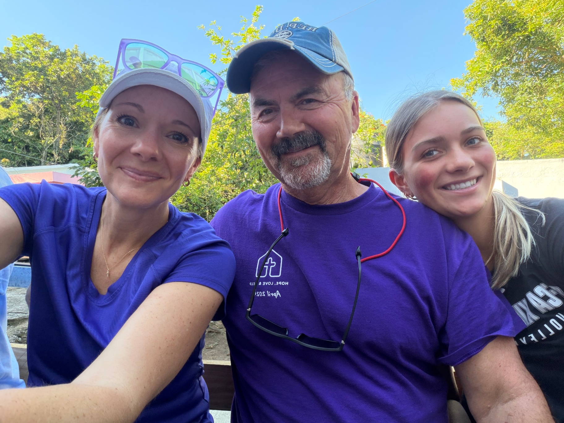Three volunteers smiling together during the trip