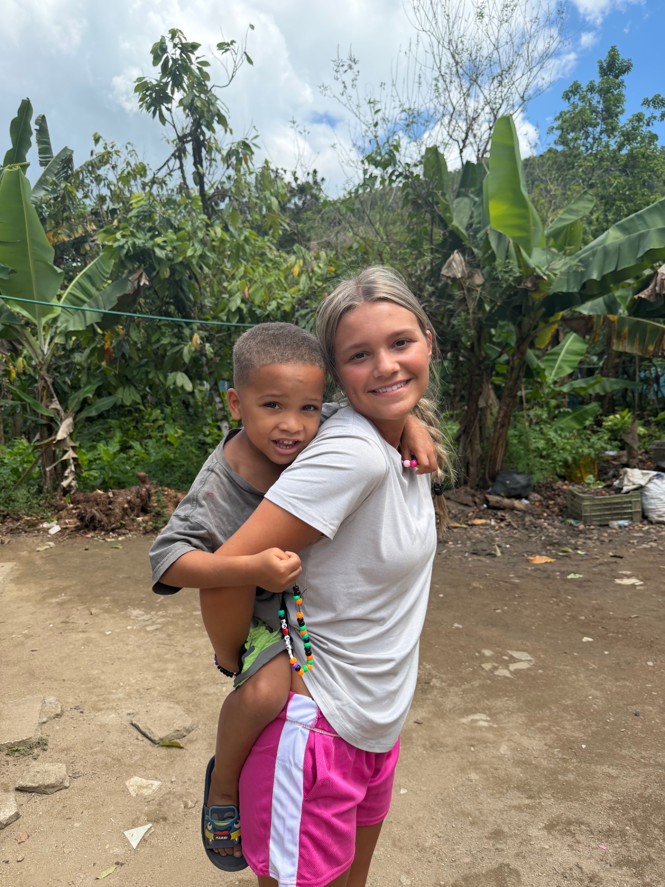 Volunteer carrying a young child outdoors