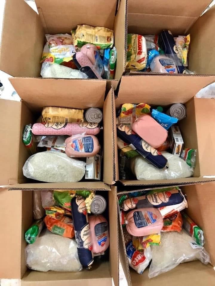 Six food boxes filled with rice, pasta, and groceries for families