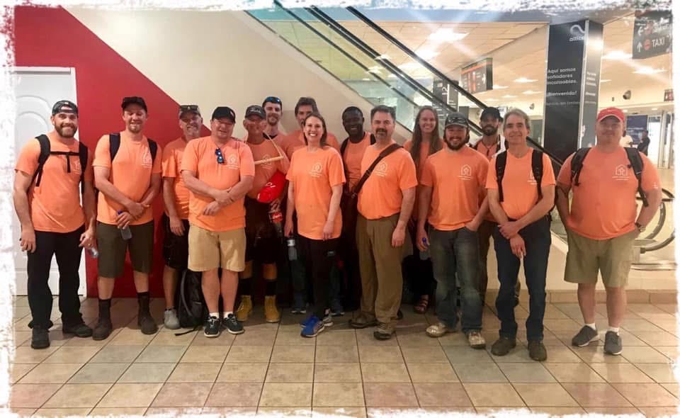Volunteer team in orange shirts at the airport ready to serve