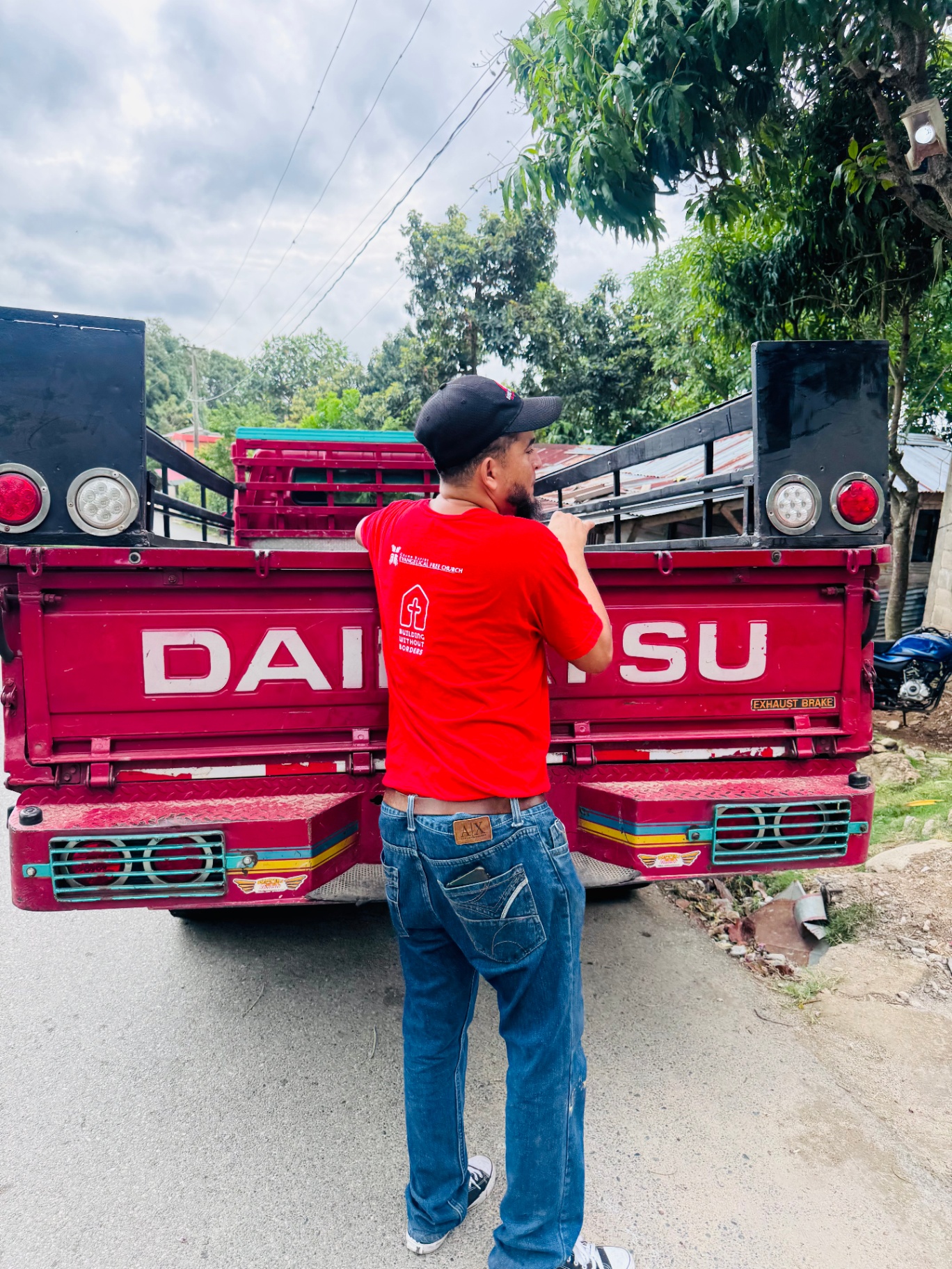 Local partner loading supplies onto a red Daihatsu truck